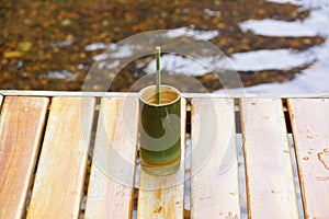 Coffee in a cup made of bamboo Put it on a wooden table in a stream