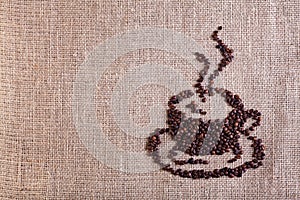 Coffee cup made of beans on burlap background