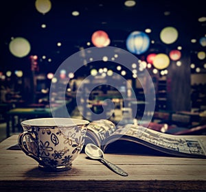 Coffee cup with magazine on wooden table