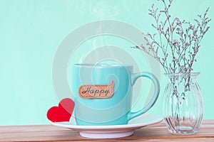 Coffee cup mug with red heart shapeand happy word tag on wooden