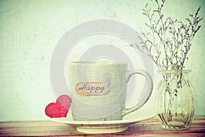 Coffee cup mug with red heart shapeand happy word tag on wooden
