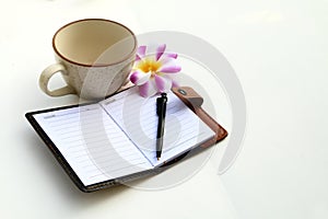 Coffee cup and notbook on white background