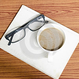 Coffee cup and notebook with glasses photo