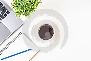 Coffee cup, notebook, laptop on a white table in the office. Working concept using technology, internet, computer. Copy space on