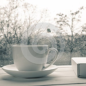 Coffee cup over mirror background in rainy day,copy space