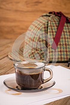 Coffee cup, paper sheets and detective hat