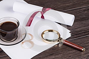 Coffee cup, paper sheets and detective magnifying glass