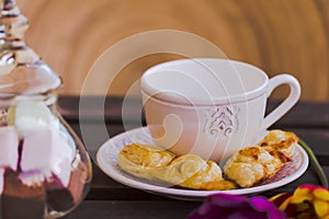 Coffee cup with pastries and sweets on wooden table