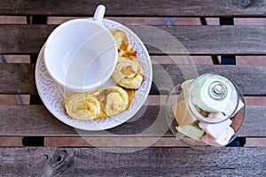 Coffee cup with pastries and sweets on wooden table