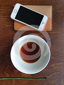 Coffee cup, phone, diary, on  wooden table