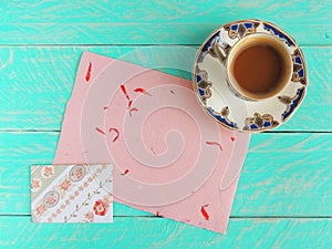 Coffee cup with pink handmade paper and envelope with roses