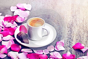 Coffee cup and pink roses petals pattern. Flat lay, top view