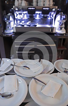 Coffee cup plates with sugar sachets over bar counter
