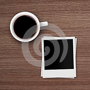 Coffee cup and polaroid photo frames on wooden table