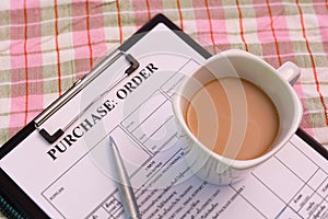 Coffee cup on purchase order form on cloth