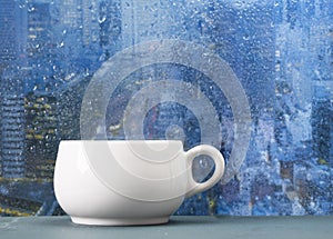 Coffee cup on a rainy day in front of the window