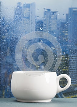 Coffee cup on a rainy day in front of the window