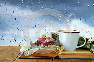 coffee cup on a rainy day over wooden table and window with rain