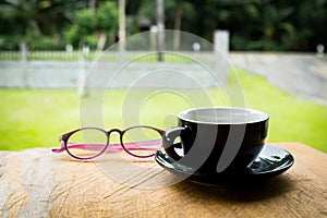 Coffee cup  and reading glasses on old wooden table