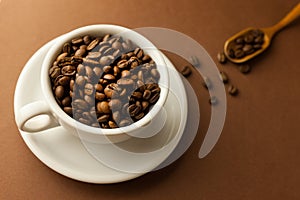 Coffee cup with roasted beans on brown table