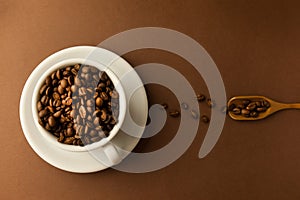 Coffee cup with roasted beans on brown table