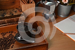 Coffee cup with roasted coffee beans and moka pot on wooden table.