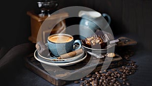 Coffee Cup on a rustic background. Espresso with cinnamon sticks , blue Cup of coffee and coffee beans on an old Board