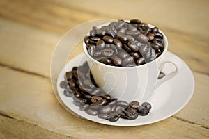 Coffee cup on the saucer with coffee beans