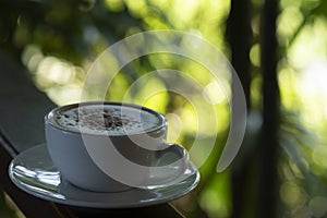 Coffee cup and saucer,that the coffee in the cup on a wooden table  and nature  green background