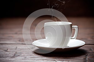 Coffee cup and saucer on old wooden table.