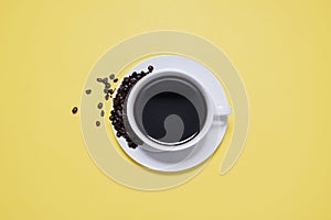 Coffee cup and saucer with spilled coffee beans