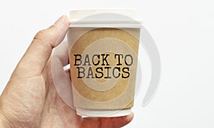 Coffee cup with sign BACK TO BASICS, business concept