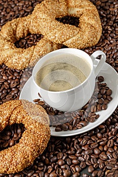 Coffee cup and simit sesame bagel from above beans background