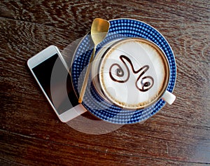 Coffee cup and smart phone on old wooden table.