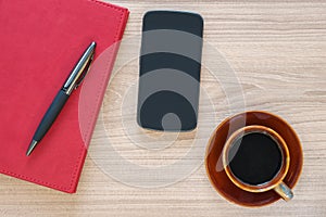 Coffee cup, smartphone and notebook on wood desk
