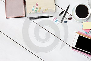 Coffee cup smartphone and pen,notebook on white wooden desk and