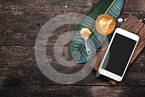 Coffee cup and smartphone on wooden table.