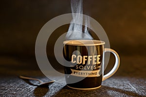Coffee cup solves everything on dark background with a spoon