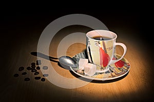 Coffee cup, spoon and coffee beans on a wooden table