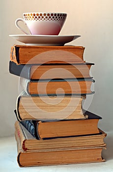 Coffee cup on stack of old books