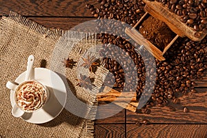 Coffee cup, star anise, cinnamon sticks and coffee-beans