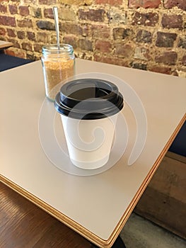 Coffee cup and sugar jar on a table top