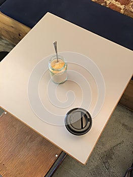 Coffee cup and sugar jar on a table top from above
