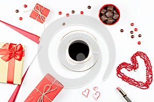 Coffee cup, sweets, lipstick, heart shape and giftbox on white background. Women`s Day concept flat lay.