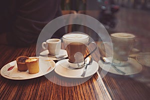 Coffee cup with sweets on the table of cafe. Coffee latte on the wood desk in coffee shop cafe restuarant,Italy