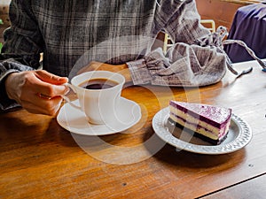 Coffee cup on the table and black rose. beautiful foaming late coffee on wooden table. afternoon refreshing drink for coffee lover