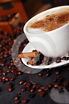 Coffee cup on the table with coffee beans around