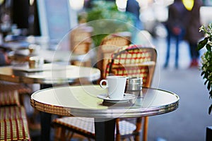 Coffee cup on a table of typical Parisian cafe