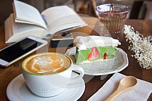 Coffee cup and tasty cake relax time book and mobile phone on ta