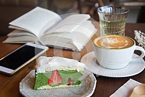 coffee cup and tasty cake relax time book and mobile phone on ta